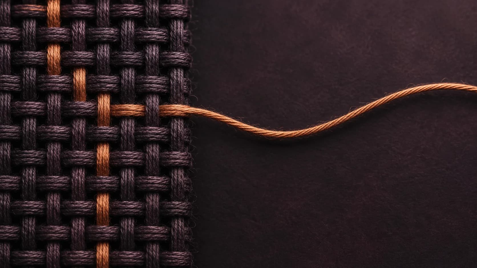 Illustrative close-up of a copper-colored thread emerging from a dark woven grid onto an open plum surface